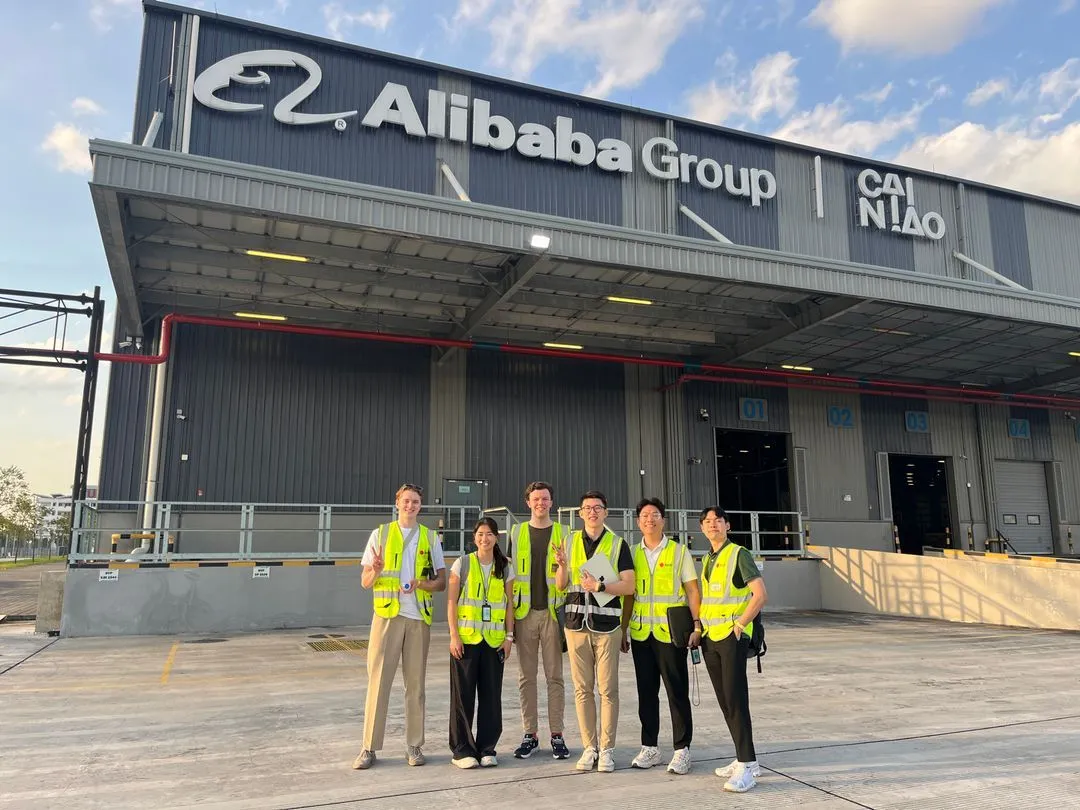 Six associates in Belli hi-vis outside an Alibaba Group Cainiao cargo facility