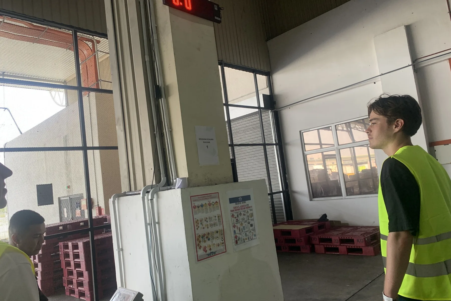 A Belli team member beside a cargo weighing display